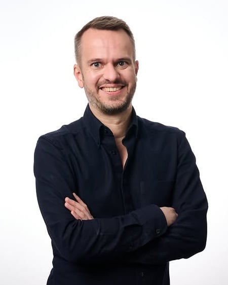 Christian Freese with arms crossed, in a dark navy shirt